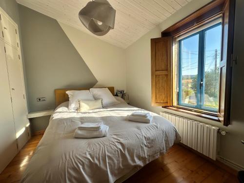 Un dormitorio con una cama con dos toallas encima. en Casa do Bidueiro, en Luou