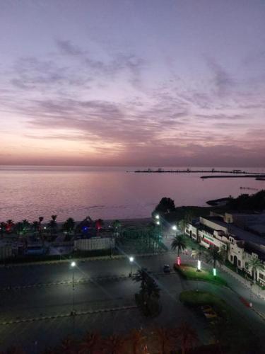 a parking lot with a view of the ocean at night at Blue Waves Hotel Abu Halifa أمواج الخليج الزرقاء أبو حليفة in Kuwait