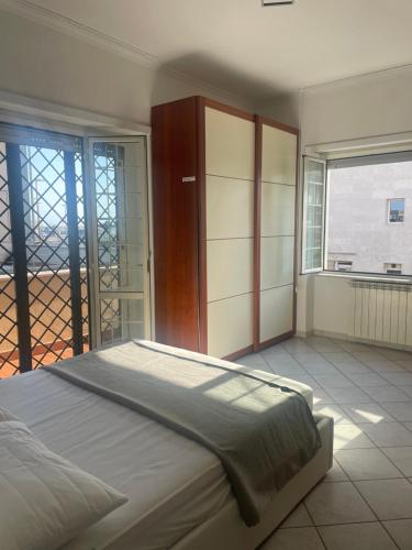a bedroom with a large bed and a balcony at ALMIA casa vacanze in Fiumicino