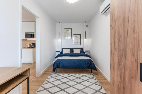 a bedroom with a bed in a white room at MW8 Apartments in Rzeszów