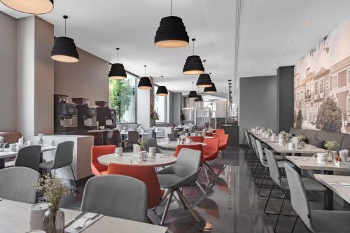 a restaurant with tables and chairs and lights at EXE Liberdade in Lisbon