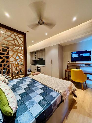 Un dormitorio con una cama y una silla amarilla. en Vaelora Stay - Luxury Studio, en Ghaziabad