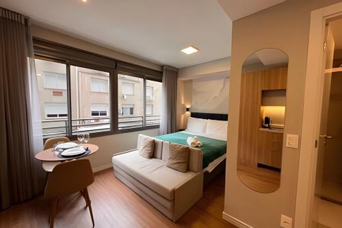 Una habitación de hotel con una cama y una mesa y un pequeño Sidx Sidx Sidx Sidx. en JP Redenção | In House, en Porto Alegre