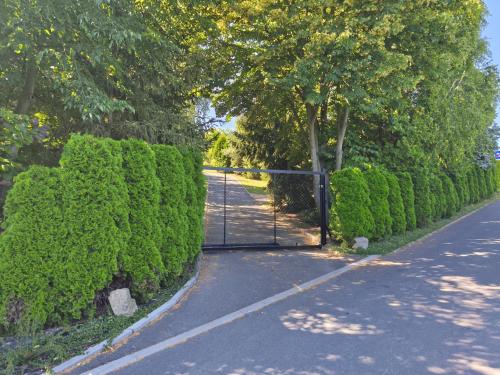 a gate in the middle of a road with bushes at Nature house Slavkov u Brna in Slavkov u Brna