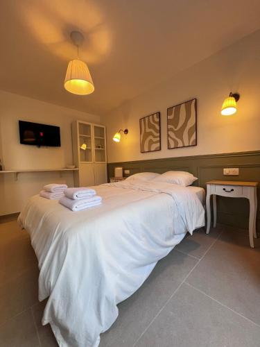 a bedroom with a large white bed with towels on it at Studio Avignon MONTFAVET in Avignon