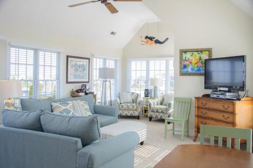 a living room with a blue couch and a tv at Lauren Lee in Nags Head