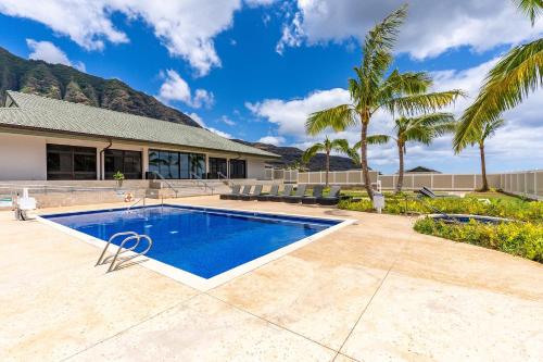 a swimming pool in front of a house with palm trees at Studio Nene by AvantStay Chic Cozy King Bed in Waianae