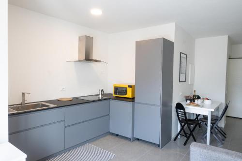 a kitchen with a sink and a table with a microwave at Civetta BLU, Blue Owl Apartments in Trento