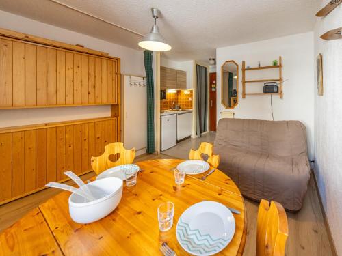 Il comprend un salon avec une table en bois et une cuisine. dans l'établissement Studio cosy 3 pers, 19m², proche pistes et commerces - FR-1-807-109, à Saint-François-Longchamp