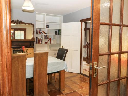 a dining room with a table and a mirror at Lilly's Bungalow in Timoleague