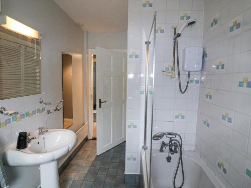 a bathroom with a shower and a sink and a tub at Lilly's Bungalow in Timoleague