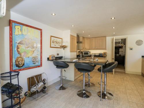 a kitchen with a counter and bar stools at The Old Reading Room in Stow on the Wold