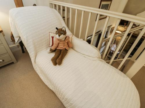 a teddy bear sitting on a white chair at The Old Reading Room in Stow on the Wold