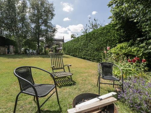 three chairs sitting in the grass in a garden at The Old Reading Room in Stow on the Wold