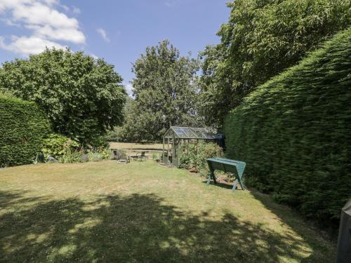 a garden with a bench in the middle of a hedge at The Old Reading Room in Stow on the Wold