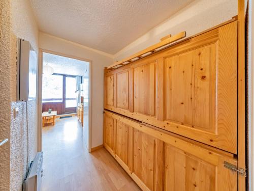 un couloir avec des armoires en bois dans une maison dans l'établissement Studio lumineux 4 pers proche pistes, TV, cuisine équipée - FR-1-807-103, à Saint-François-Longchamp