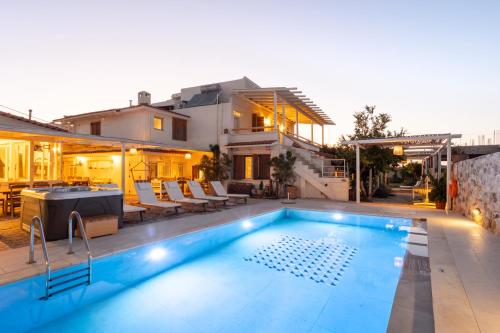 a swimming pool in front of a house at Villa Arancia in Pigi