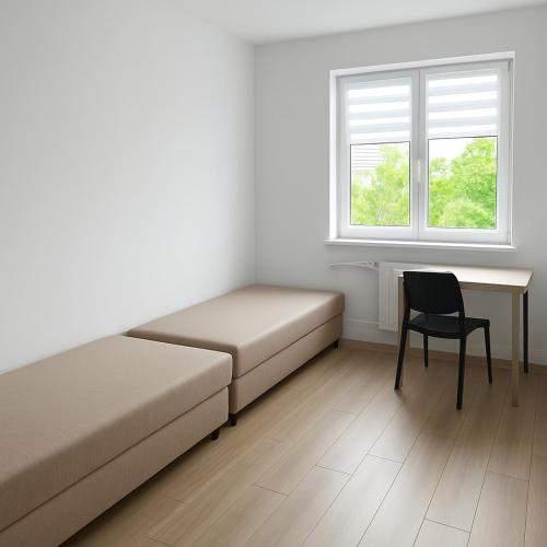 a room with a bed and a desk and a chair at Noclegi Gdynia Chrzanowskiego in Gdynia