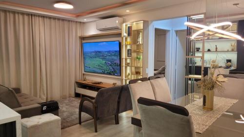 a living room with a dining table and a television at Lindo apartamento centro de Floripa in Florianópolis