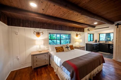 a bedroom with a large bed and a kitchen at The Woodsman Lodge in Eureka Springs
