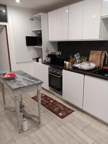a kitchen with white cabinets and a table in it at MAISON Centre LOCHES ET RIVIERE 37600 in Loches