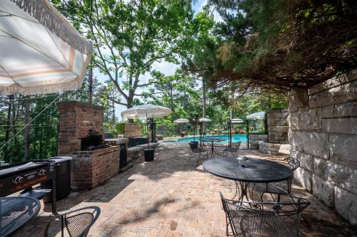a patio with a table and chairs and a pool at The Woodsman Lodge in Eureka Springs
