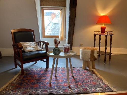 un salon avec une table et une chaise dans l'établissement Au pied du Logis Royal, à Loches