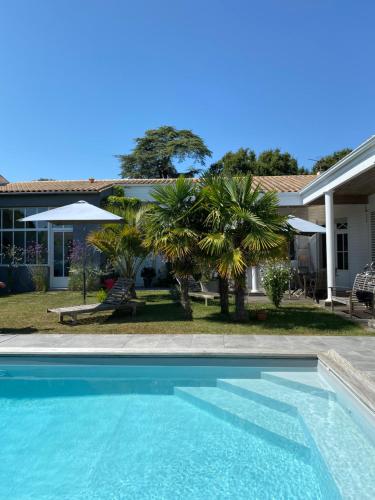 une piscine devant une maison dans l'établissement Maison M, chambre privée accès jardin piscine et jacuzzi près de La Rochelle, à La Rochelle