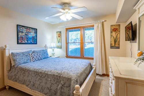 a bedroom with a bed with a ceiling fan and a window at Life O Rily in Duck