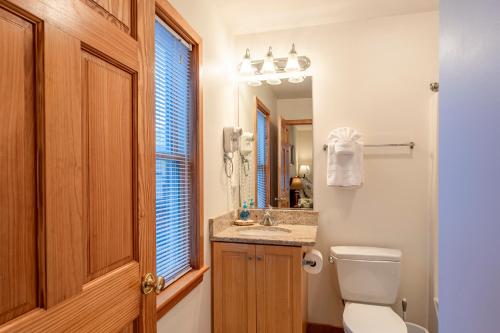 a bathroom with a toilet and a sink and a mirror at Life O Rily in Duck