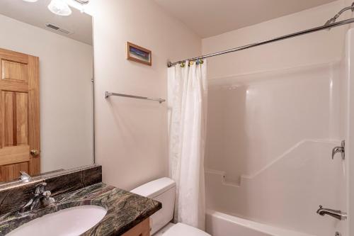 a bathroom with a sink and a toilet and a shower at Life O Rily in Duck