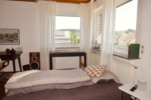 a bedroom with a bed in front of a window at Homestay - Panoramablick über Büdingen in Büdingen