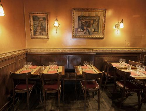 a dining room with tables and chairs and portraits on the wall at Bistrot Les Sans Culottes in Paris