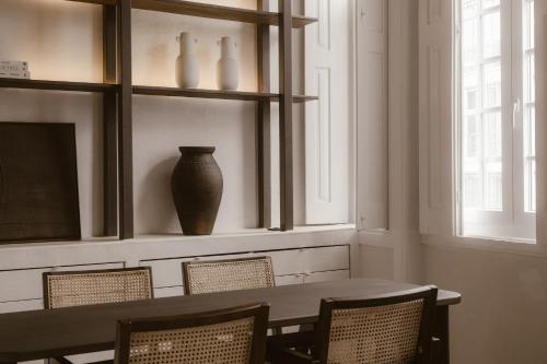 a dining room with a table and chairs and a vase at Beige Tranquil Escape by the Sea in Matosinhos