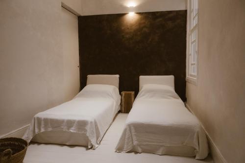 two beds in a small room with white sheets at Beige Tranquil Escape by the Sea in Matosinhos