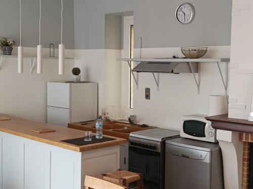 - une cuisine avec un comptoir et un four micro-ondes dans l'établissement Maison triplex en centre ville historique, à Cahors