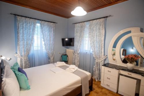a bedroom with a bed and a mirror and curtains at Μικρός Παράδεισος - Αγροτουριστική Κατοικία 