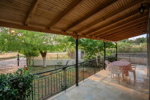 a patio with a table and a fence at Μικρός Παράδεισος - Αγροτουριστική Κατοικία 