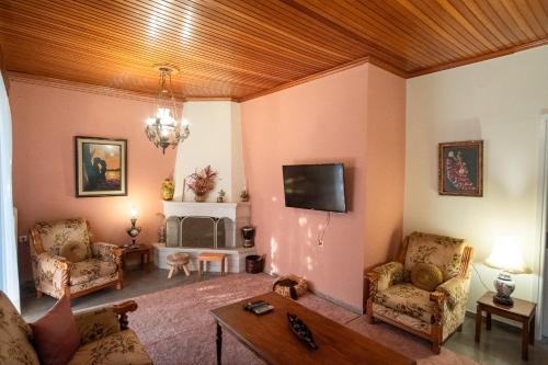 a living room with a couch and a tv at Μικρός Παράδεισος - Αγροτουριστική Κατοικία 