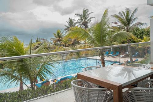 a balcony with a table and chairs and a swimming pool at Morros Vitri Beachfront By Huespedia in Bolivar