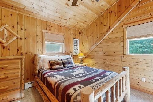 a bedroom with a bed in a log cabin at The Den In Franconia in Franconia