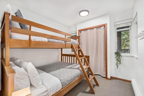 a bedroom with two bunk beds and a window at Amazing Village Location with PRIVATE Hot Tub in Whistler