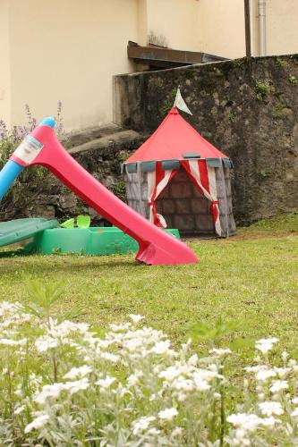 a red slide in a yard with a play house at La Piazzetta in Menaggio