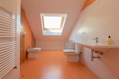 ein Bad mit 2 WCs, einem Waschbecken und einem Fenster in der Unterkunft Gavian House in A Coruña