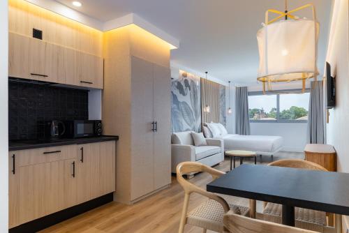 a kitchen and a living room with a table and a couch at HA Retiro Suites in Madrid