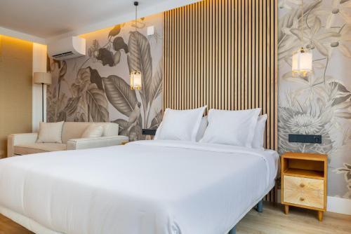 a bedroom with a large white bed and a couch at HA Retiro Suites in Madrid