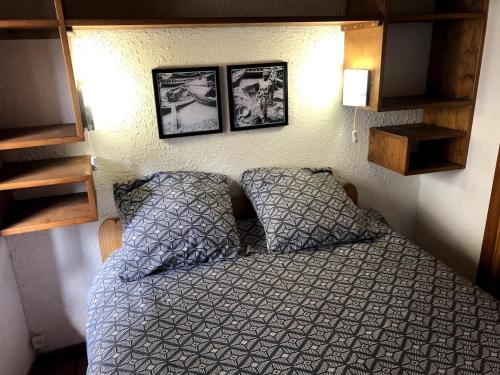 a bedroom with a bed and two pictures on the wall at Appartement Les Angles villages in Les Angles