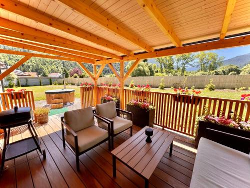 a deck with chairs and a wooden pergola at Domček pod Vežami s vírivkou a grilom, pri termálnom kúpalisku in Liptovský Ján