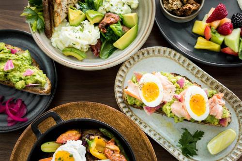 a table topped with plates of food with eggs and toast at Carmel Mission Inn in Carmel