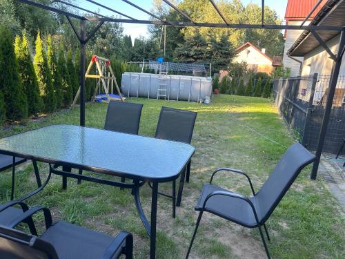a table and chairs in a backyard with a playground at Villa Kraków in Kraków